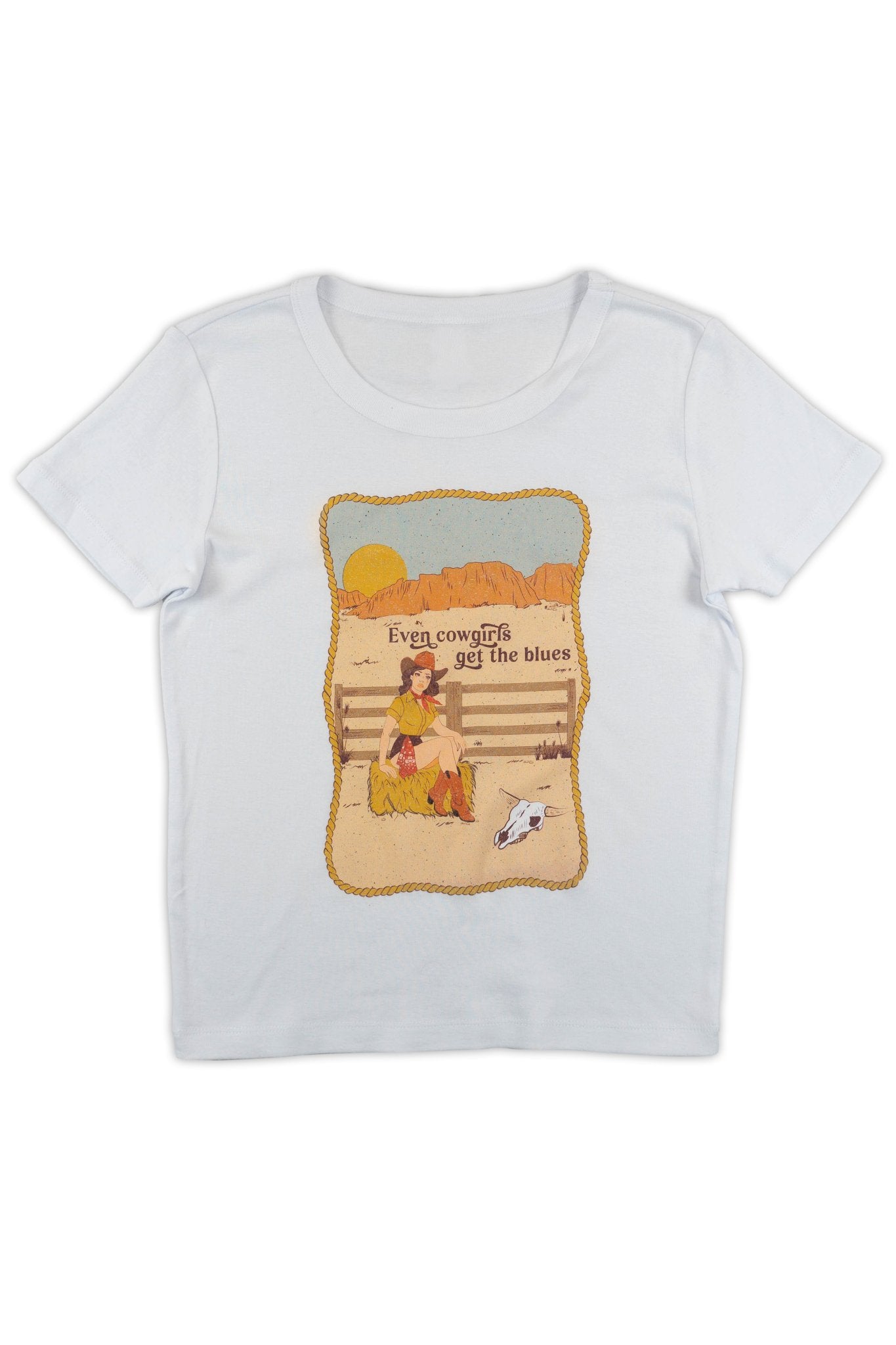White t-shirt with a graphic design of a girl cryng by a fence with text that reads "Even Cowgirls get the blues" on a white background