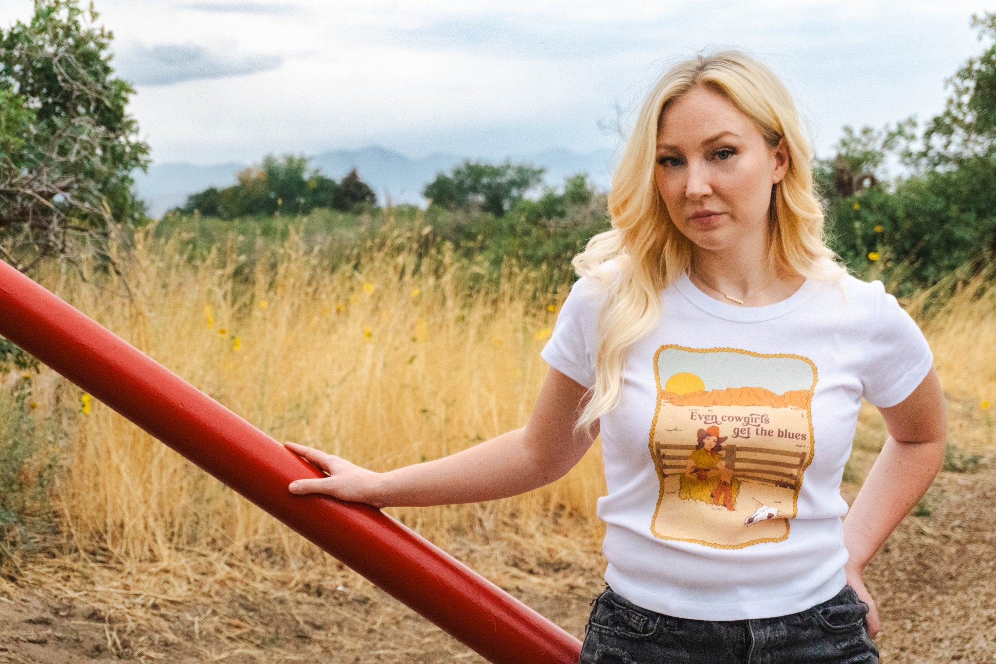 Woman wearing a white t-shirt with a graphic design in a field